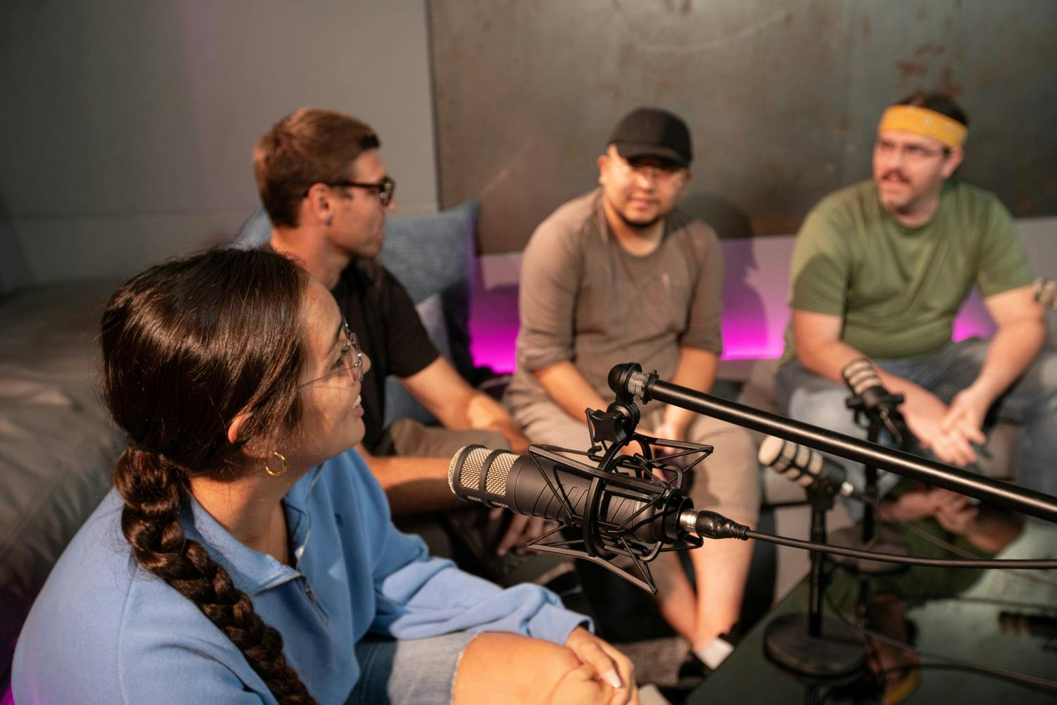 A close-up perspective of a panel discussion, featuring the participants in mid-conversation with podcasting microphones.