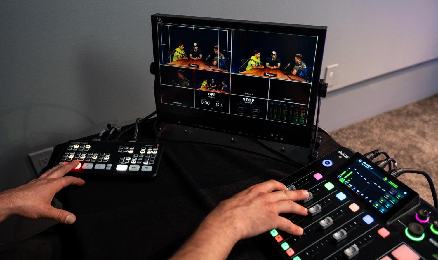 Close-up of a broadcasting switcher with multiple screens showing a podcast recording in progress.