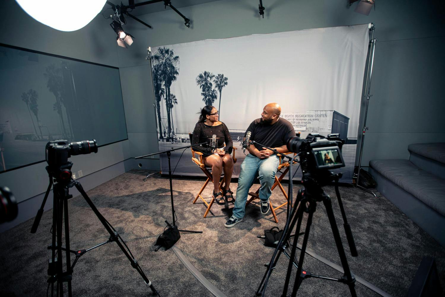 A behind-the-scenes look at a video interview production featuring a camera operator, video monitoring equipment, and interviewees.